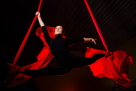 Girl aerialist doing twine on aerial canvases. Acrobatics in the airの写真素材