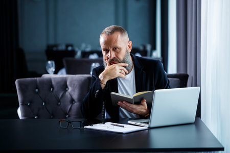 An adult successful male businessman is working on a new project and looks at the growth charts in a...