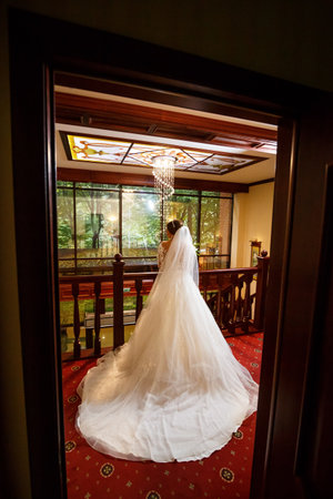 Bride in a beautiful white dress on the wedding day with a bouquet in her handsの写真素材