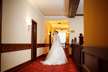 Bride in a beautiful white dress on the wedding day with a bouquet in her handsの写真素材