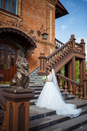 bride in a white dress with a bouquet in her hands and a crown on her headの写真素材
