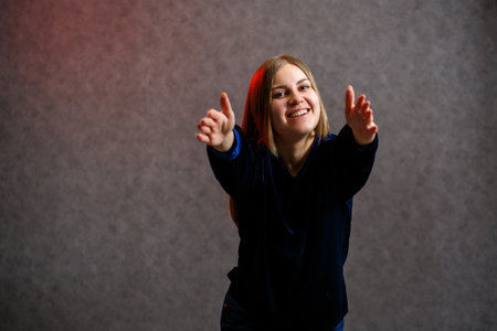 Girl in blue sweater on gray beautifully poses backgroundの写真素材