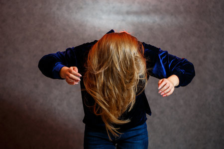 Girl in blue sweater on gray beautifully poses background