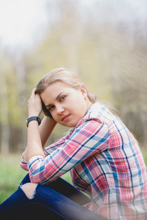 Beautiful girl in flowering trees in early spring. Bright sun and natureの写真素材