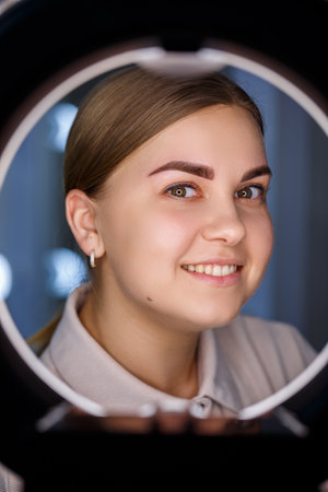 A close-up of the face of a young woman who has just had a permanent eyebrow tattoo done.の写真素材
