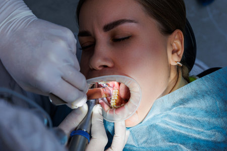 Dentist with dental instruments, examining patient's teeth in dental clinic office. The concept of medicine, dentistry and healthcare. Dental equipment. selective focusの写真素材