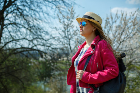 beautiful girl in a dress walking in the spring forest where the trees bloomの写真素材