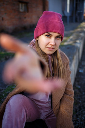 stylish girl model in a brown coat, pink suit and pink hat smiles beautifully. The trends of modern fashion. Fashionable image. Bright emotionsの写真素材