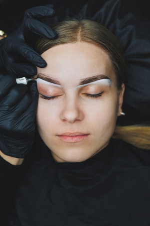 Young woman during professional eyebrow mapping procedure before permanent makeupの写真素材