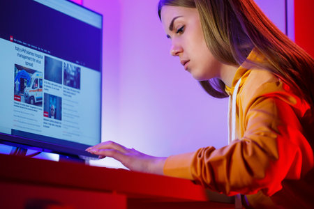 girl freelancer looks on the computer screen news about forest fires and the virus COVID-19の写真素材
