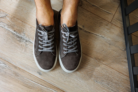 Male legs in gray casual sneakers. Comfortable men's summer shoes.