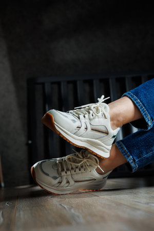 Collection of women's leather shoes. Female legs in leather white casual sneakers. Stylish women's...