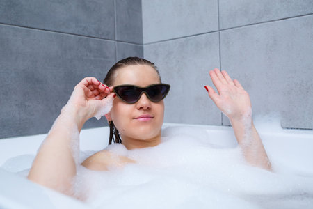 Young woman with sunglasses getting spa treatment in a beauty salon, inside an interior room. Relax...