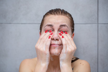 Face skin care. Woman applying facial cleanser on face closeup. Girl using cleansing cosmetic...