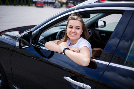 stylish fashionable beautiful girl sitting in the salon of a black business class car. Young woman...