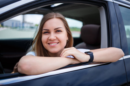 Elegant blonde beautiful woman sitting in a luxury car. The girl is stylish and earns a lot....