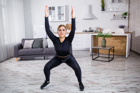 Young beautiful athletic girl in leggings and a top does stretching exercises. Healthy lifestyle....