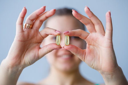 Hand with pills. The woman is taking medications to improve immunity. Daily norm of vitamins, effective preparations, modern pharmacy for health.の写真素材