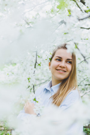 Portrait of beautiful romantic lady in apple trees blossomsの写真素材