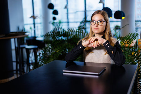 Young pretty woman businesswoman in glasses working at office desk in front of laptop, work online