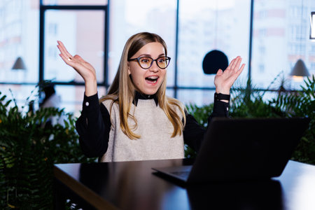 Young pretty woman businesswoman in glasses working at office desk in front of laptop, work onlineの写真素材