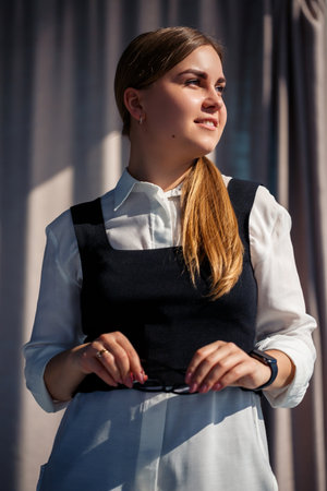 Confident business woman boss standing in modern office, female leader, business owner thinking about future success, planning new opportunitiesの写真素材