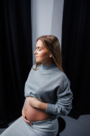 Cute pregnant woman in sweater and skirt with tummy. Happy elegant pregnant woman. A woman is expecting a childの写真素材