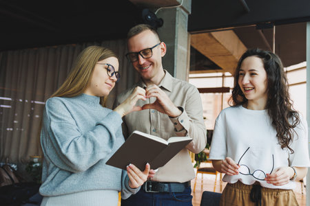 Modern pregnant woman working in office with colleagues. A young successful man helps a pregnant colleague at work. A beautiful pregnant woman works in the office. Modern pregnant womanの写真素材