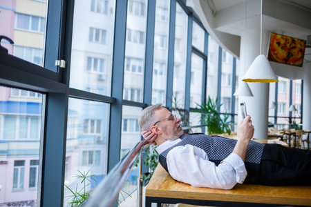 Adult male businessman resting and looking at a tablet in search of ideas for a project to develop new technologiesの写真素材
