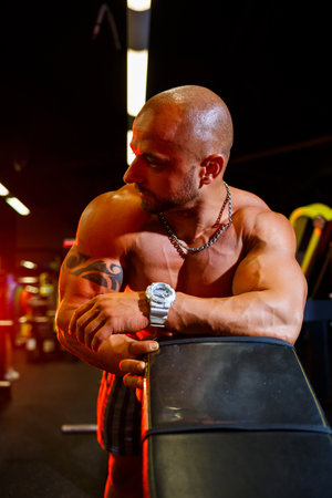 Strong, adult, fit, muscular male trainer posing for a photo shoot in the gym in sportswear, showing off his musclesの写真素材
