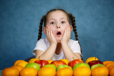 Little girl in white T-shirt love fruitの写真素材