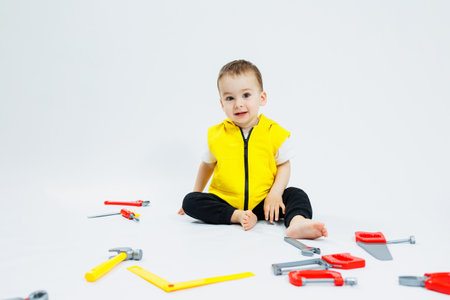 A 2-year-old boy plays with plastic construction tools. Children's plastic toys. Children's builder's set.の写真素材