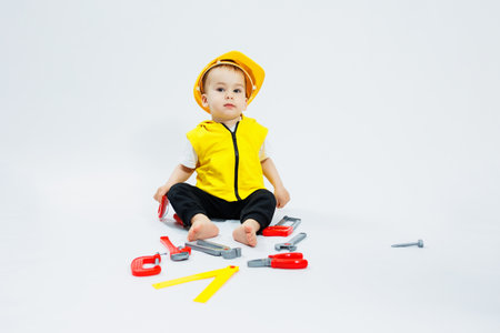 A 2-year-old boy plays with plastic construction tools. Children's plastic toys. Children's builder's set.の写真素材