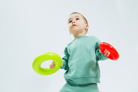 Little boy playing logic educational games with plastic pyramid isolated on white background. A happy child plays with an educational toy. The baby is one year and four months oldの写真素材