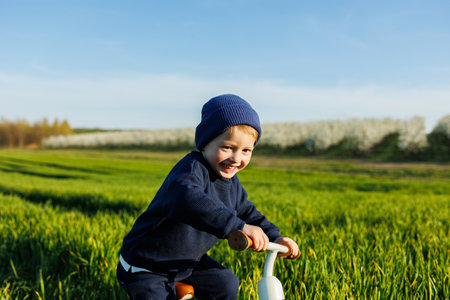 Happy emotional child. A cheerful boy walks on a children's jogging track on the green grass in the garden. Running track for childrenの写真素材