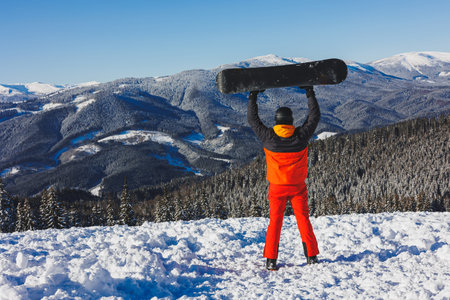 Winter sport. A snowboarder walks down a snowy slope in winter on the snow. Snowboarding, winter freerideの写真素材