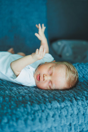 Portrait of a sleeping baby. A newborn baby is sleeping. A baby in a white cotton bodysuitの写真素材