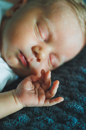Portrait of a sleeping baby. A newborn baby is sleeping. A baby in a white cotton bodysuit
