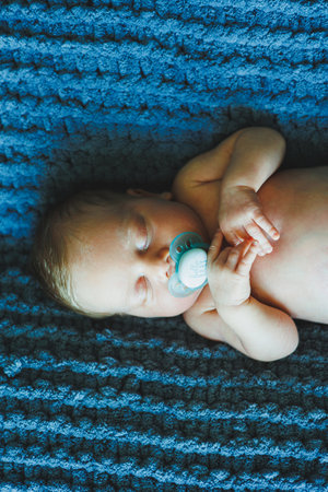 A newborn baby sleeps on a knitted blanket. A blanket made of natural fabric for a newborn baby....