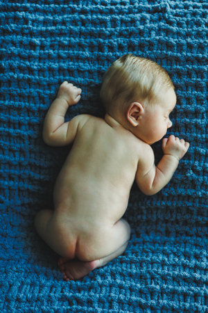 A newborn baby sleeps on a knitted blanket. A blanket made of natural fabric for a newborn baby....