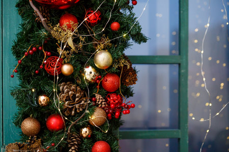 Christmas decoration from fir branches and toys on the window in a cozy home. Christmas toys in the...