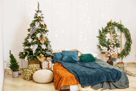 Christmas tree with toys in the bedroom. Beautifully decorated house for the new year with tree and bed decorationsの写真素材