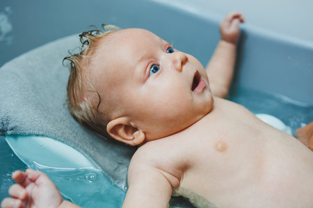 A newborn baby takes a bath. Parents bathe the child. The newborn is bathed. The newborn is smiling....