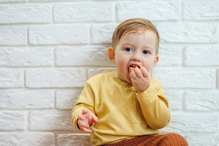 Cute smiling kid eating one fresh juicy tangerineの写真素材