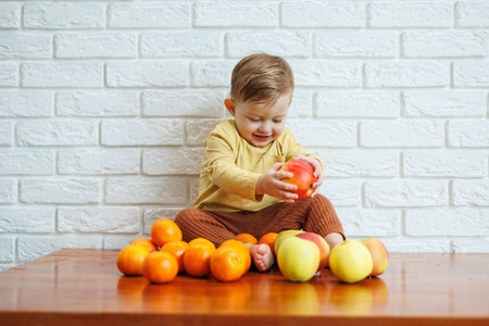 Cute smiling kid eating one fresh juicy red apple. Healthy fruits for young childrenの写真素材
