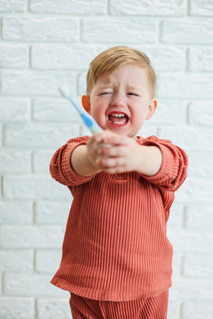 A small child learns to brush his teeth with a toothbrush. Dental hygiene in children