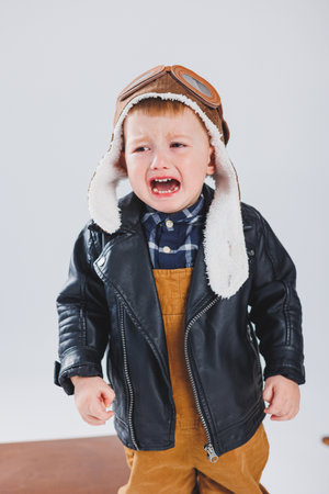 A little boy of 3 years old is crying and screaming with emotion. An emotional child is sobbing.の写真素材