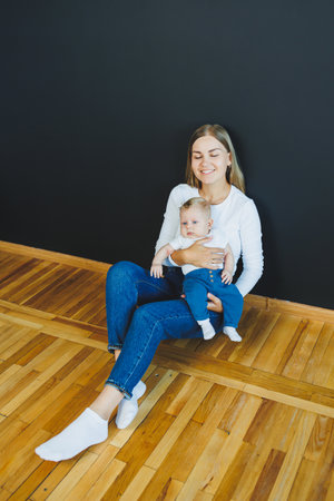 A smiling young mother holds her newborn son in her arms. Happy mother. Son and mother. Concept of happy motherhoodの写真素材