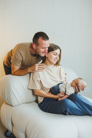 Happy young family with a newborn baby. Beautiful mother and father kissing their child. Parents and...