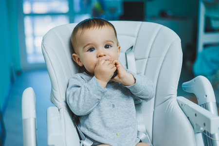 A little 8-month-old boy is sitting on the floor and playing with wooden toys. Children's ecological toysの写真素材